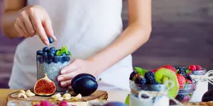 Das Bild zeigt eine Frau, die eine Basenfasten Speise in Form mit Obst und Gemüse vorbereitet, Wunsch Hotel Mürz in Bad Füssing, Deutschland