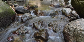 Bild eines fließenden Gebirgsbaches der Steine umspült, Fasten nach Buchinger, Online-Fasten, Intervallfasten