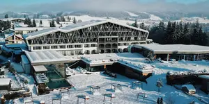 Das Bild zeigt die Außenansicht des verschneiten Hotelbereichs Rosenalp in Oberstaufen.