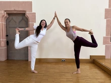 Das Bild zeigt zwei Frauen, die gemeinsam eine Yogapose machen, Fasten nach Buchinger und Basenfasten